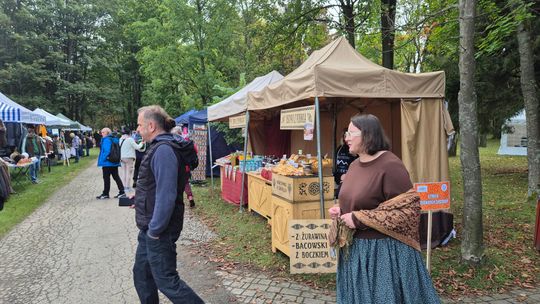 grupa ludzi przy stołach z grzybami i boksach sprzedażowych w Wysowej-Zdroju